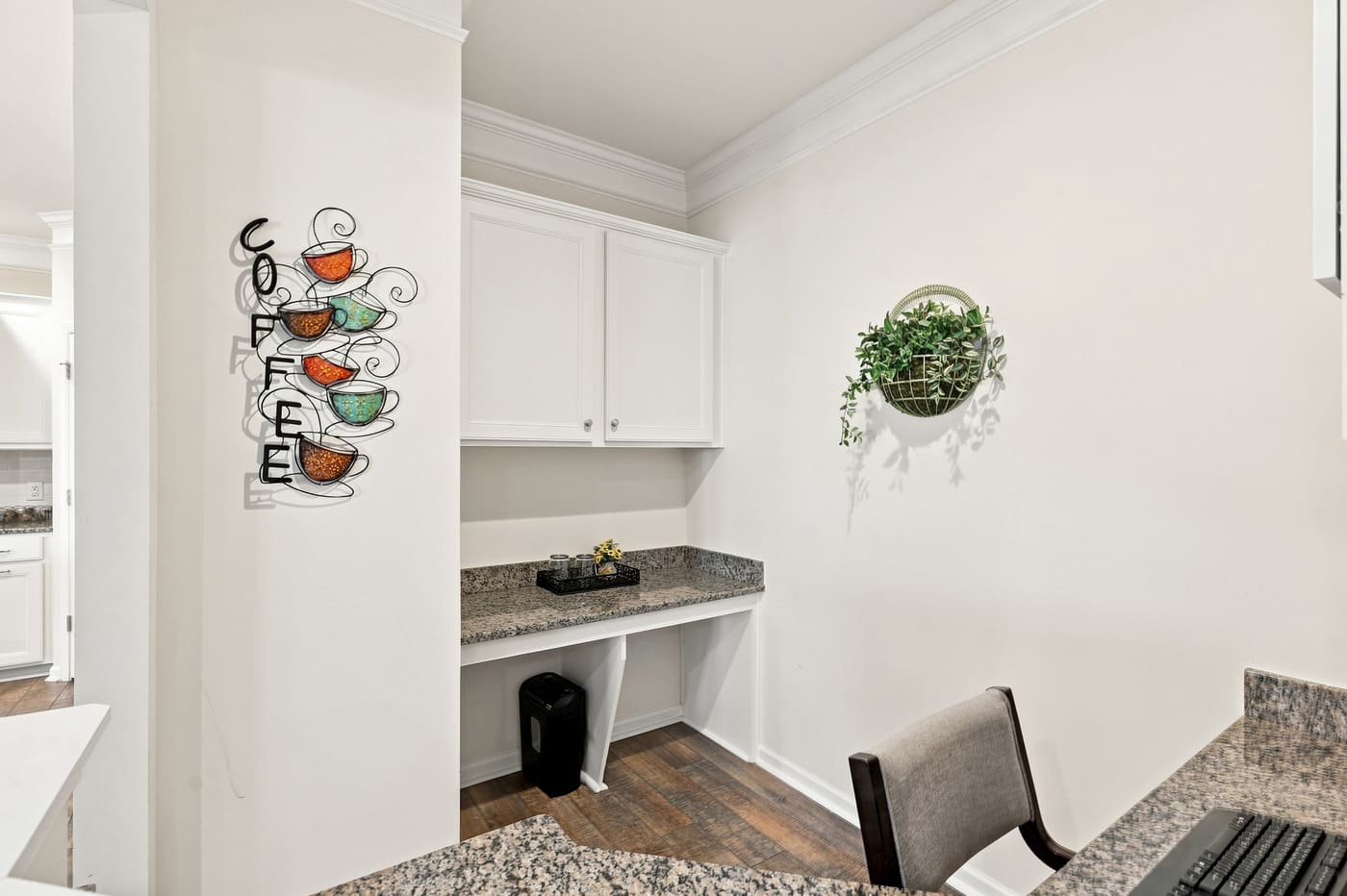 A built-in coffee bar alcove with granite counter and upper cabinetry.