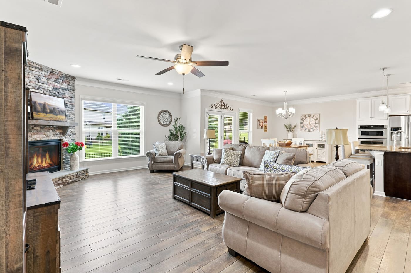 The family room with its floor-to-ceiling stacked-stone fireplace and timber mantel.